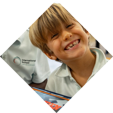 Primary student smiling at lunch table with hot lunch menu program at International School Turks and Caicos Islands